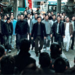 Offizielles Filmplakat von "Stadt der Gewalt – Shinjuku Incident" mit Jackie Chan in der Hauptrolle. Zu sehen ist eine düstere Straßenszene mit mehreren Personen.